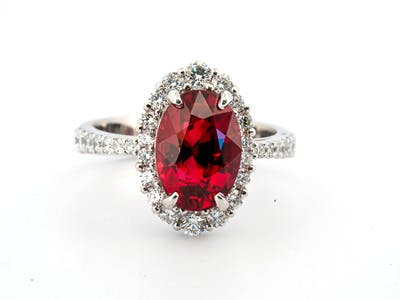 Oval ruby ring set in a graduated halo of round brilliant diamonds set in platinum