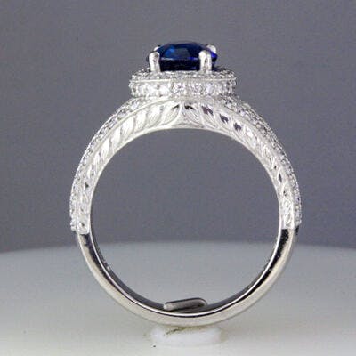 Profile view of the platinum split shank halo ring set with a blue sapphire